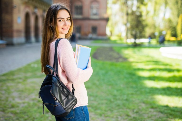 a girl in a university carrying a bag and a set of books