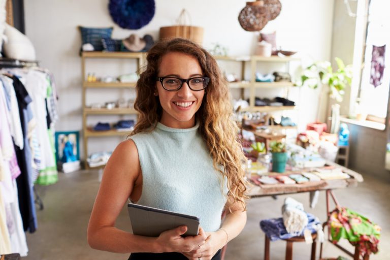 entrepreneur inside her shop holding a checklist